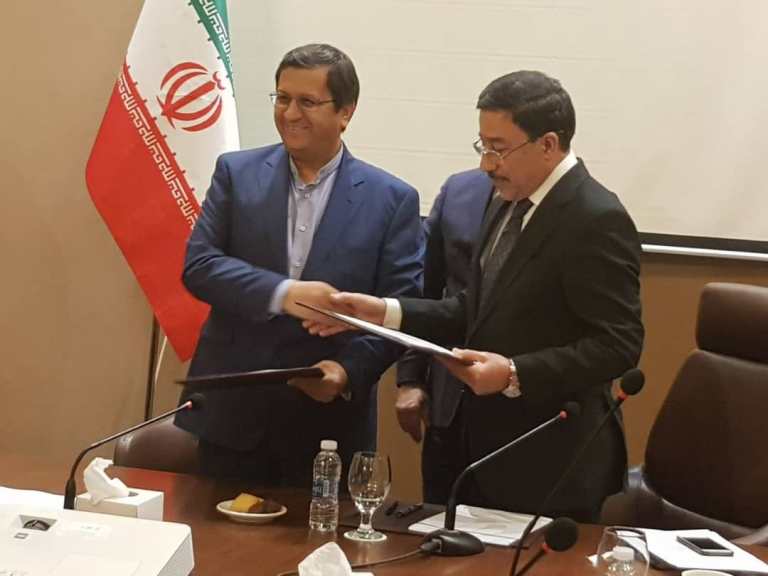 Central Bank of Iran (CBI) Governor Abdolnaser Hemmati, left, shakes hands with his Iraqi counterpart Ali al-Alaq following signing a financial agreement in Baghdad, 6 Feb 2019. (Central Bank of Iran)